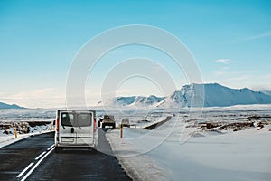 On the road in winter, with a cars driving on highway in Iceland