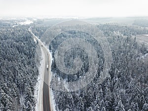 Road through the winter forest. Aerial view landscape