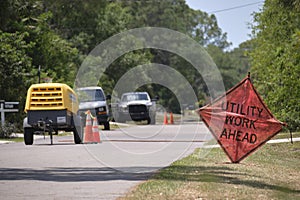 Road work ahead sign on street site as warning to cars about construction and utility works