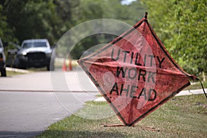 Road work ahead sign on street site as warning to cars about construction and utility works