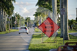 Road work ahead sign on street site as warning to cars about construction and utility works