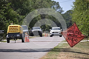 Road work ahead sign on street site as warning to cars about construction and utility works