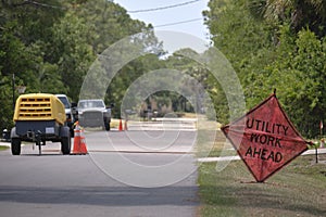 Road work ahead sign on street site as warning to cars about construction and utility works