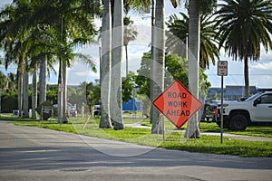 Road work ahead sign on street site as warning to cars about construction and utility works