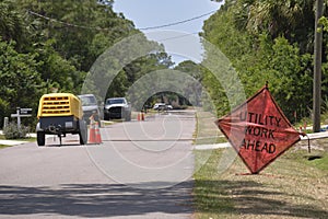 Road work ahead sign on street site as warning to cars about construction and utility works