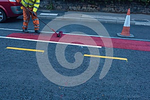 Road workers applying hot melt traffic resistant paint for white, yellow and red road marking lines