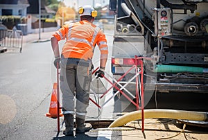 road workers and his truck cleaning the sewers on a road