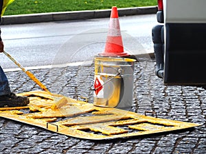 Road workers paint lane markings for taxis with yellow Marcas Viales color in Portugal