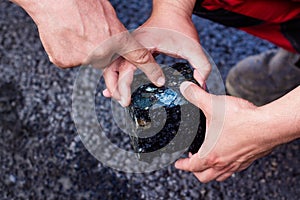 Road workers take a cube of asphalt