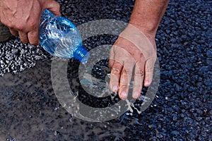 Road workers take a cube of asphalt