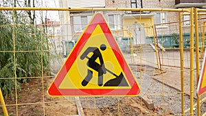 Road works signs on a fence, construction and building industry.