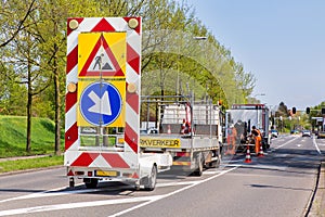 Road works with trucks and traffic signs