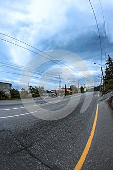 The road with the yellow line and clouds