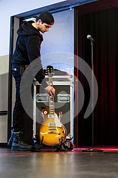 Roadie putting down the guitar for a band member