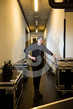 Roadie standing between some flightcases