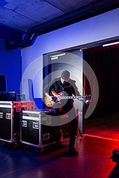 Roadie tuning a guitar for the guitarist