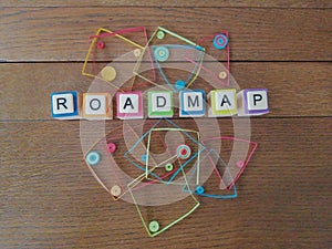 Roadmap in letters on wood background with colorful geometric shapes