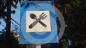 Roadside Eatery: Fork and Spoon Sign on Blue Board Alongside Dehradun City Road, Uttarakhand, India