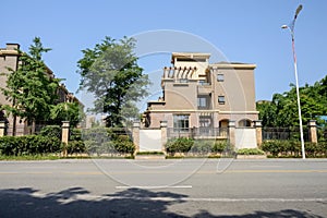 Roadside fenced dwelling buildings in sunny summer