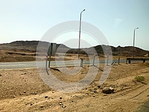 The roadside, highway with asphalt in the desert with sand, bump and sand dunes in a hot tropical country