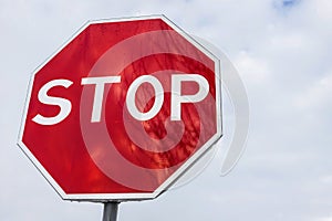 roadside red stop sign on a cloudy background. Sign isolated