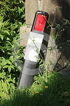 Roadside reflective marker post by end stone wall