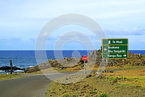 Roadside Signpost for Anakena beach, Ahu Tongariki, Hanga Roa town center and StopPARE sign against Pacific ocean, Easter Island