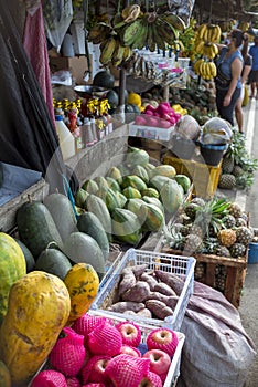 A roadside stall selling watermelons, sweet potatoes, papayas, pineapples and other locally harvested fruits.