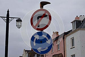 A roadsign on Sidmouth esplanade which shows a mini roundabout but with no right turn. This is because the high street is one way