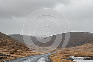 Roadtrip in Iceland driving over empty road during rainy weather close to West fjords