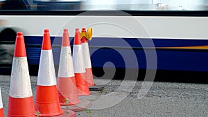 Roadworks cone flashing on UK motorway at evening with traffic passing