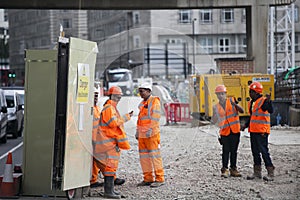 Roadworks near Tower Hill were manual workers are working as a team. They have a break.