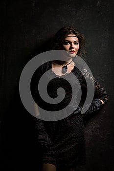 Roaring Twenties. Woman portrait in the style of Gatsby. Low key. Beautiful young woman in a lace black dress.