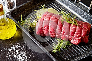 Roast of beef with rosemary on plate pot on black