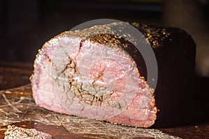 Roast beef, sliced â€‹â€‹on cutting board.  Wooden background,copy space and selective focus Close up