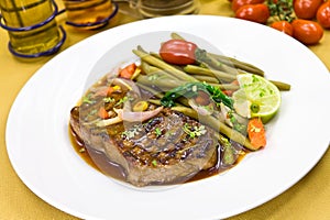 Roast big steak sirloin on green dish close up
