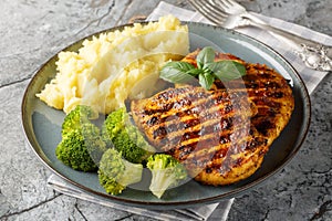 Roast breast grilled chicken with broccoli and mashed potatoes closeup on the plate. Horizontal