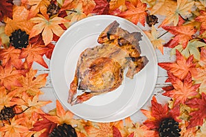 Roast chicken with Autumn and Fall season background. Fake maple leaf on wood table. Harvest cornucopia and Thanksgiving day