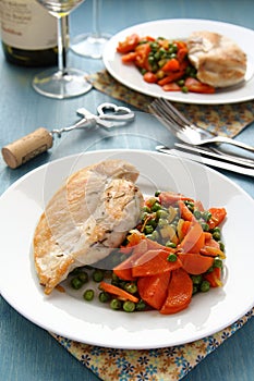 Roast chicken breast with vegetables on white plate