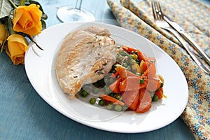 Roast chicken breast with vegetables on white plate