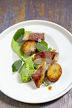 Roast chicken with fondant potatoes, pea mousse, pea puree, garlic flowers and nasturtium leaves