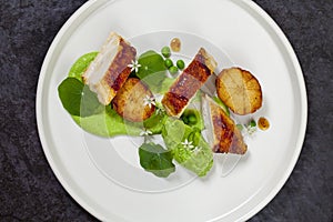 Roast chicken with fondant potatoes, pea mousse, pea puree, garlic flowers and nasturtium leaves