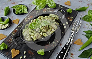 Roast chicken with pesto sauce and pine nuts in a cast iron pan