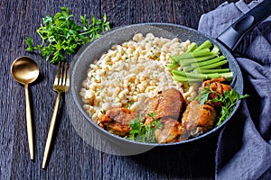 Roast chicken thighs with pasta in a skillet