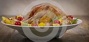 Roast chicken and various vegetables on a white plate