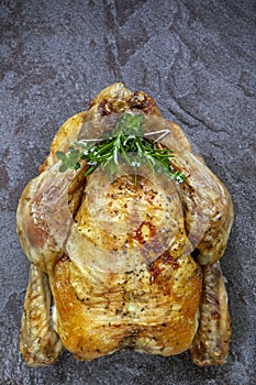 Roast Chicken Whole Top View on Slate Stuffed with Fresh Herbs