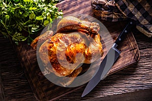 Roast chicken whole on a wooden cutting board