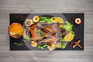 Roast duck stuffed with apples and orange sauce on a shale board. Festive dinner. delicious dish. top view. place for text
