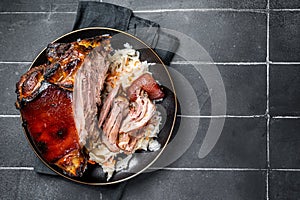 Roast Pork Ham Hock, knuckle with Sauerkraut on a plate. Black background. Top view. Copy space