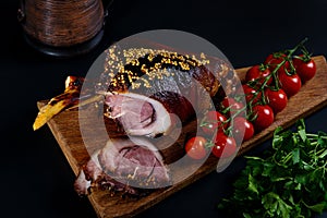 Roast pork knuckle and ingredients close-up on a slate board.